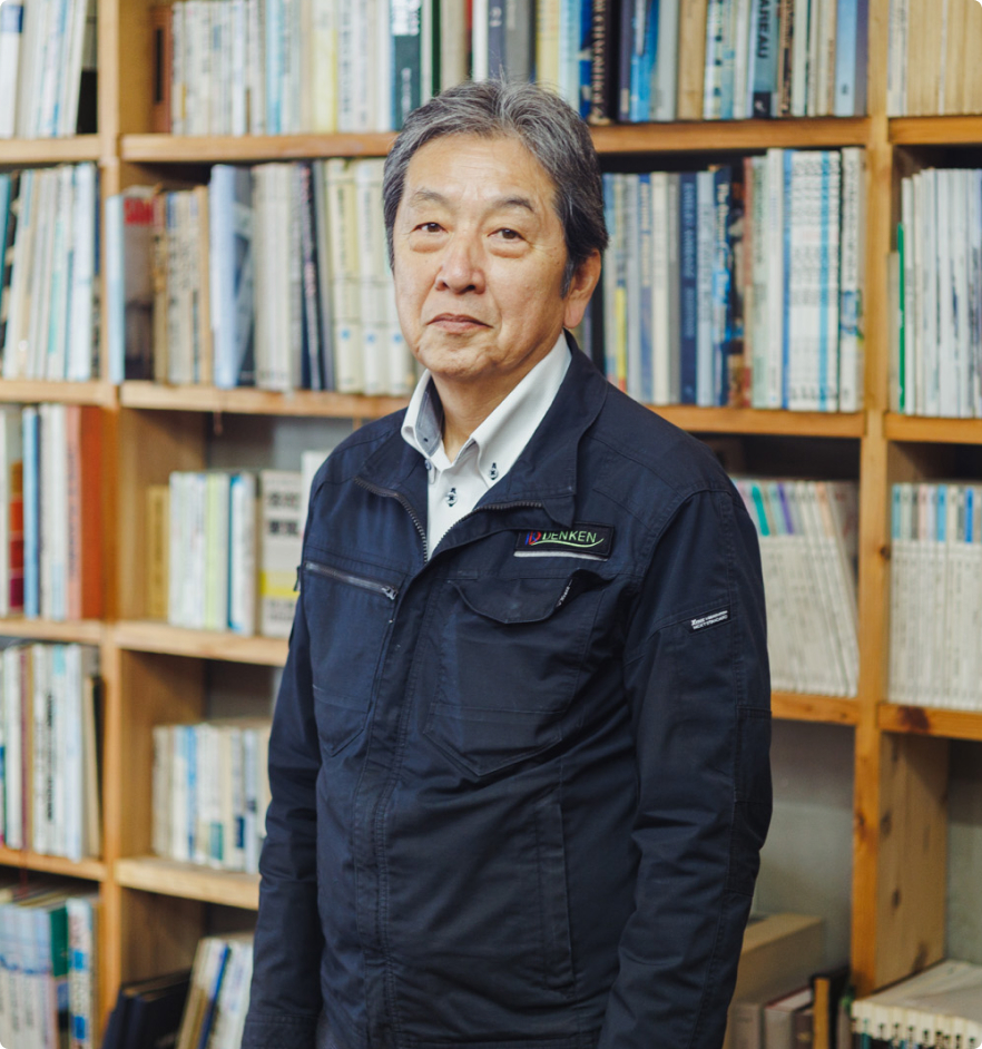 書棚を背にした代表取締役 佐方雅宣